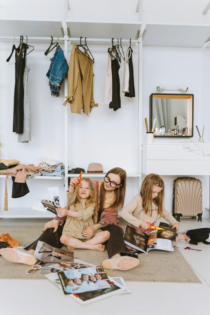 A mother and her daughters enjoy crafting together in a stylish wardrobe setting, fostering creativity.